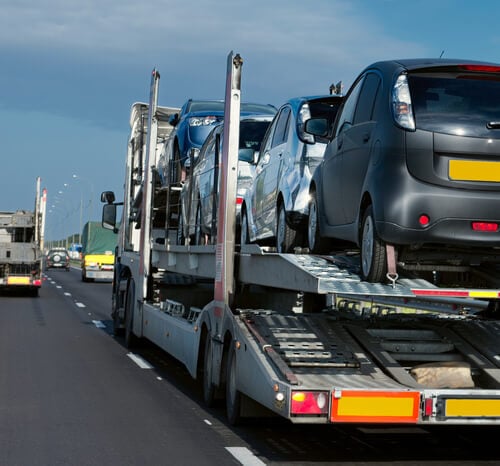 An auto carrier with cars on the way to do a door to door auto transport delivery