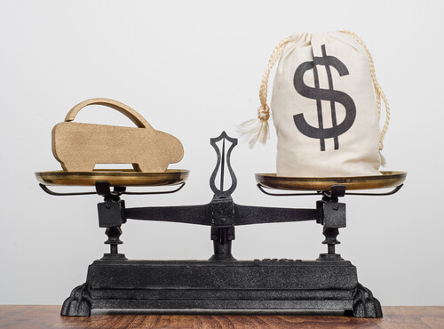 a scale with a car and a money bag to show balance