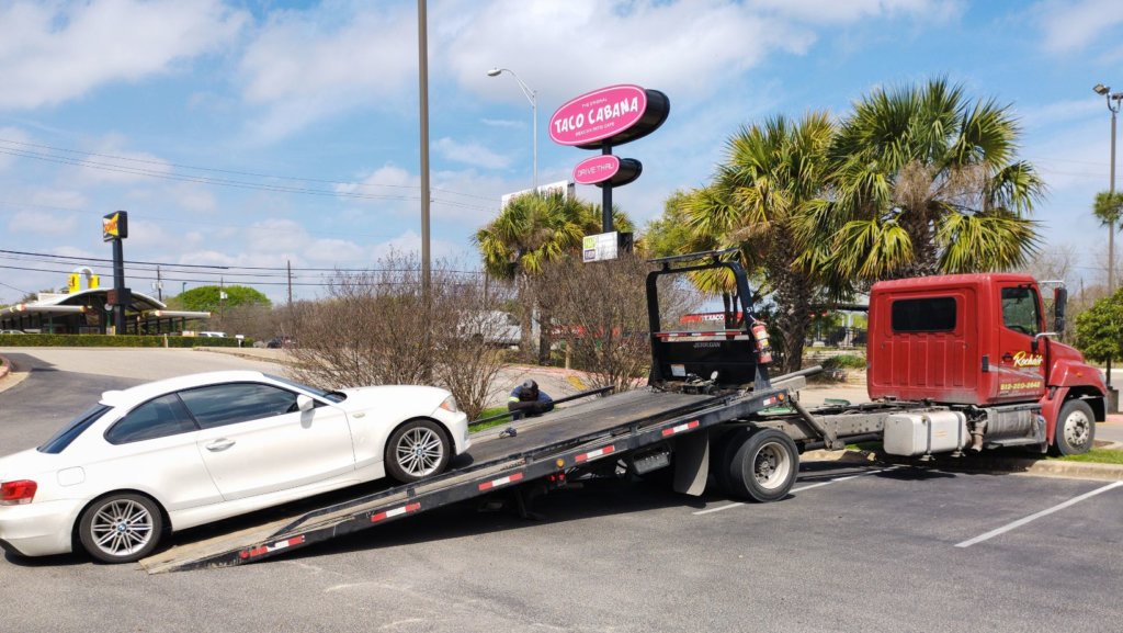 Car being loaded onto a transport truck for shipment