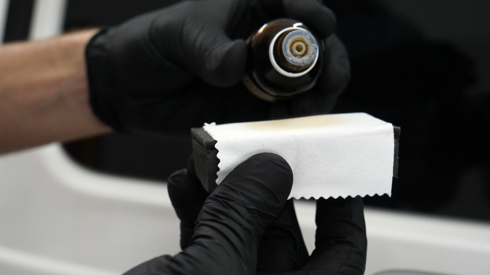 Hands applying ceramic coating to a motorcycle