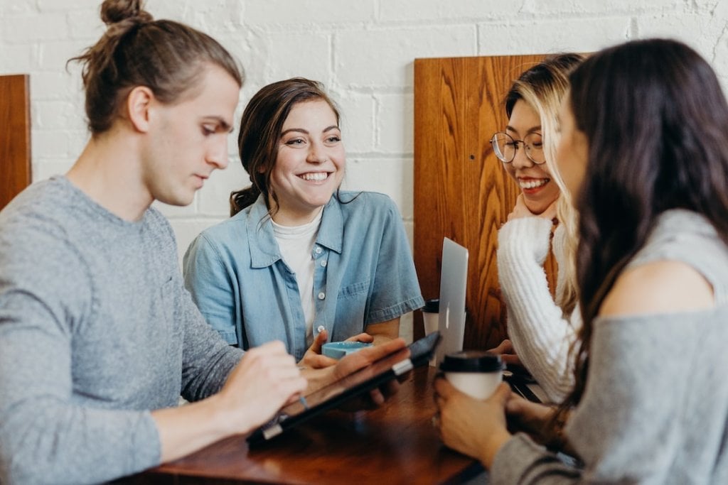 A group of people sitting around a table sharing car shipping reviews