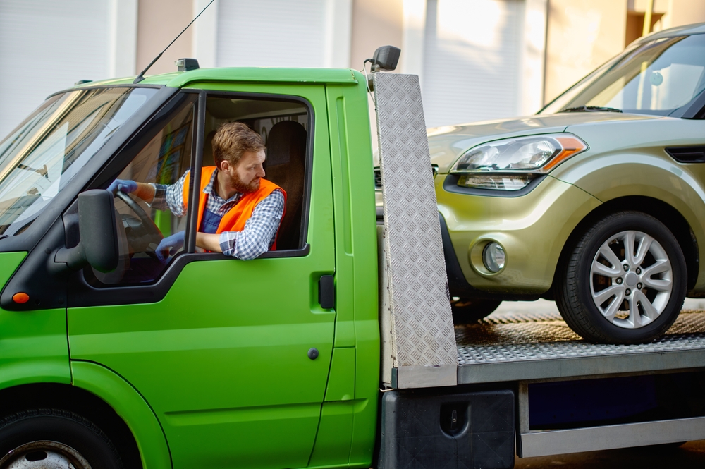 Car being loaded onto an open carrier for shipping | “Expedited Auto Shipping Costs