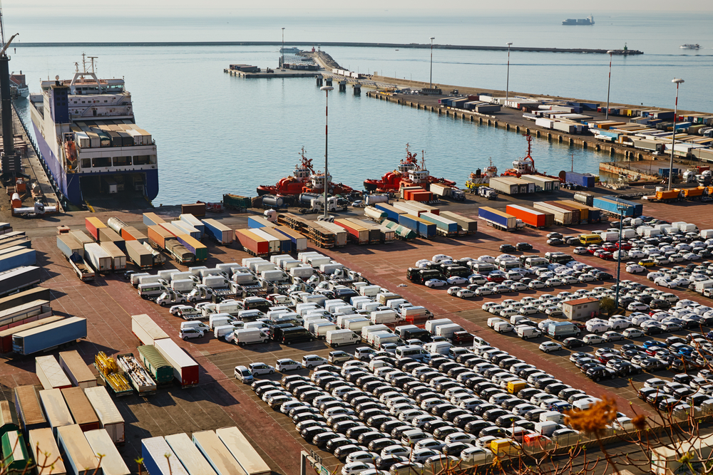 Diverse range of vehicles in a shipping yard, illustrating factors affecting shipping costs.